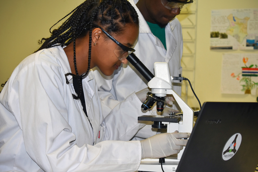 Student using microscope in lab.